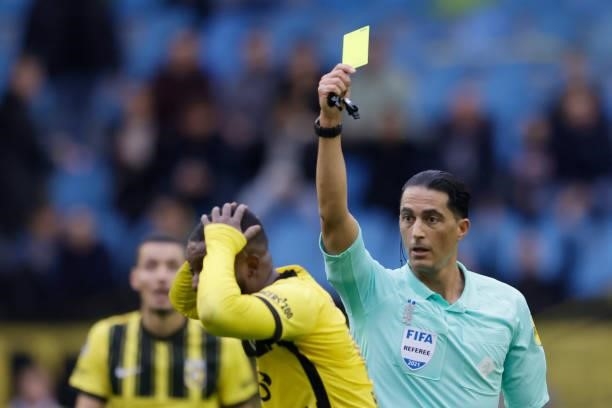 Referee Serdar Gozubuyuk gives a yellow card to Riechedly Bazoer of Vitesse during the Dutch Eredivisie match between Vitesse v Feyenoord at the...
