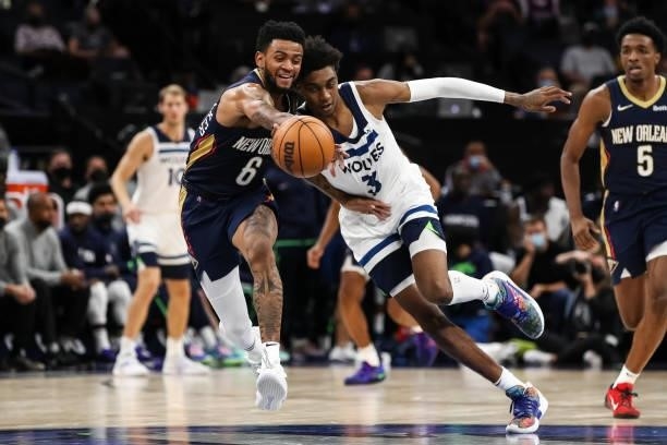 Nickeil Alexander-Walker of the New Orleans Pelicans and Jaden McDaniels of the Minnesota Timberwolves compete for the ball in the fourth quarter of...