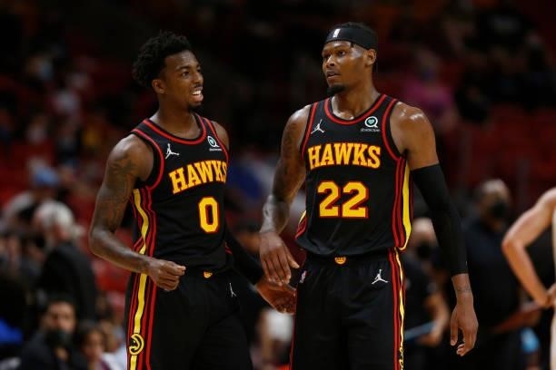 Brandon Goodwin and Cam Reddish of the Atlanta Hawks look on during a preseason game against the Miami Heat on October 4, 2021 at FTX Arena in Miami,...