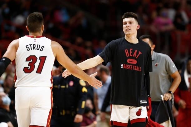 Tyler Herro of the Miami Heat high-fives teammate Max Strus during a preseason game against the Atlanta Hawks on October 4, 2021 at FTX Arena in...