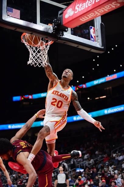 John Collins of the Atlanta Hawks dunks the ball during a preseason game against the Cleveland Cavaliers on October 6, 2021 at State Farm Arena in...