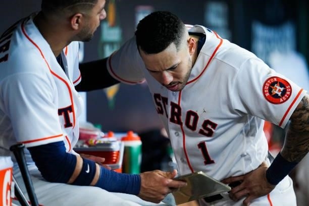 Carlos Correa of the Houston Astros and Yuli Gurriel look at a device in the dugout during Game 1 of the ALDS between the Chicago White Sox and the...
