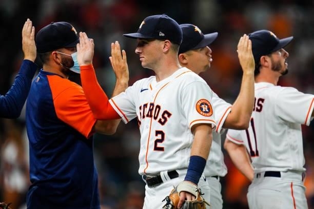 Alex Bregman of the Houston Astros high-fives with teammates after the Houston Astros defeated the Chicago White Sox in Game 1 of the ALDS at Minute...
