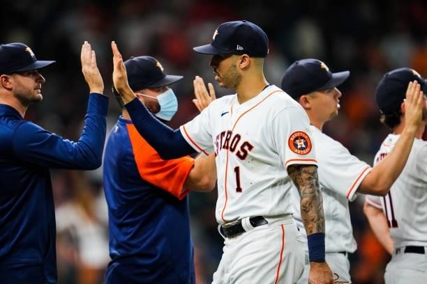 Carlos Correa of the Houston Astros high-fives with teammates after the Houston Astros defeated the Chicago White Sox in Game 1 of the ALDS at Minute...