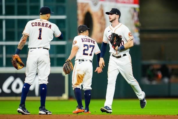 Kyle Tucker of the Houston Astros high fives Jose Altuve and Carlos Correa after the Houston Astros defeated the Chicago White Sox in Game 1 of the...