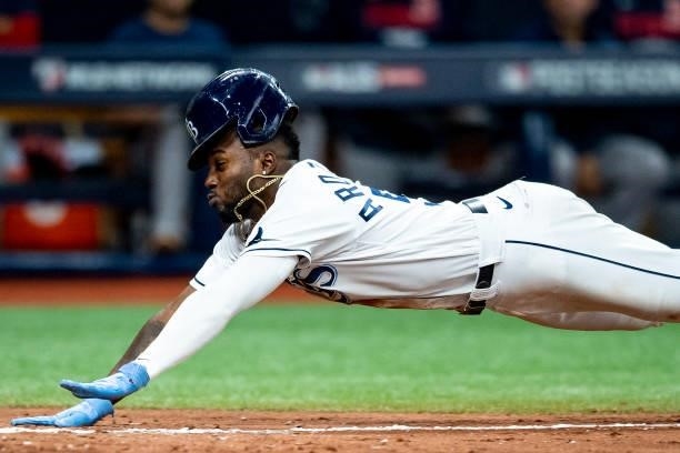 Randy Arozarena of the Tampa Bay Rays slides as he steals home plate during the seventh inning of game one of the 2021 American League Division...