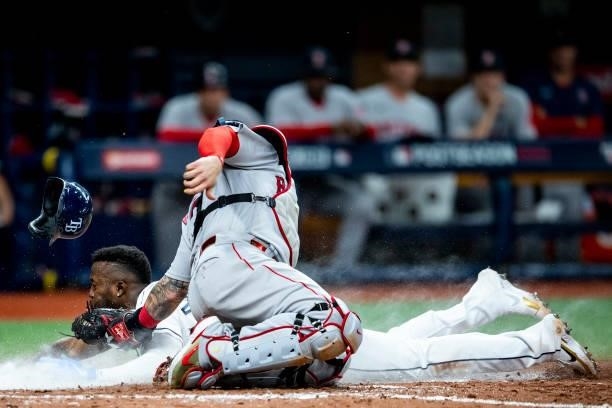 Randy Arozarena of the Tampa Bay Rays slides as he steals home plate and beats the tag of Christian Vazquez of the Boston Red Sox during the seventh...