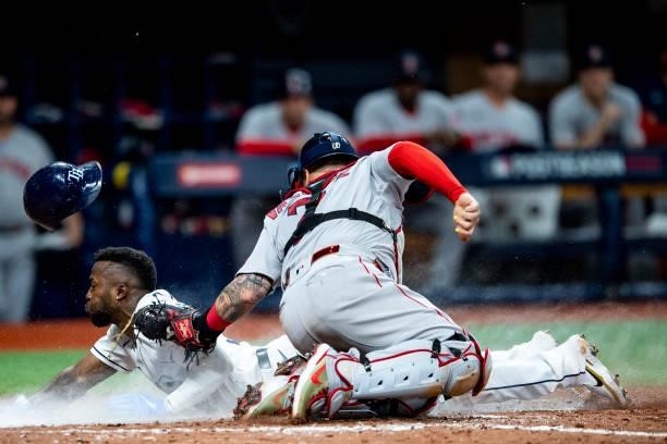 Randy Arozarena of the Tampa Bay Rays slides as he steals home plate and beats the tag of Christian Vazquez of the Boston Red Sox during the seventh...