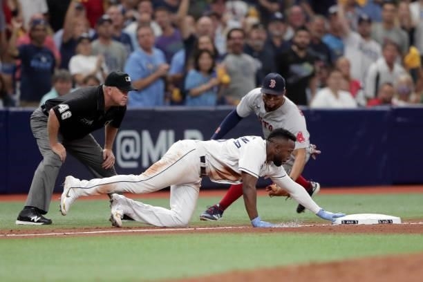 Randy Arozarena of the Tampa Bay Rays gets back safely to third base in the bottom of the seventh inning during Game 1 of the ALDS between the Boston...
