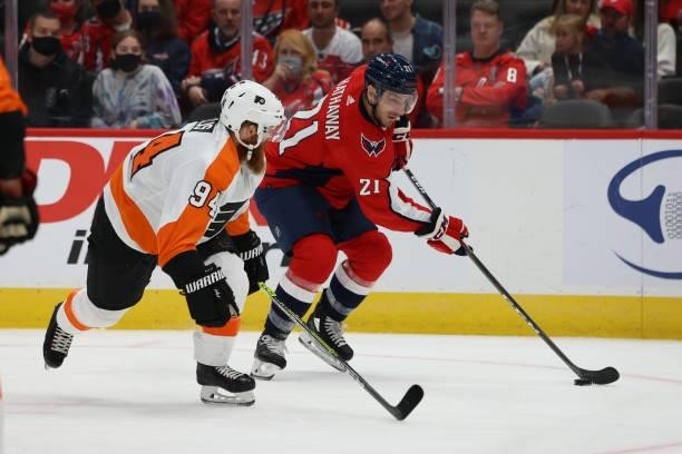 Washington Capitals right wing Garnet Hathaway protects the puck from a pressuring Philadelphia Flyers defenseman Ryan Ellis during a game between...