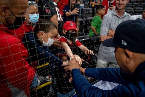 Manager Alex Cora of the Boston Red Sox greets family after a victory in game two of the 2021 American League Division Series against the Tampa Bay...