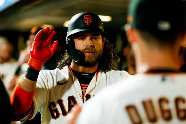 Brandon Crawford of the San Francisco Giants celebrates with teammates in the dugout after hitting a solo home run in the eight inning during Game 1...