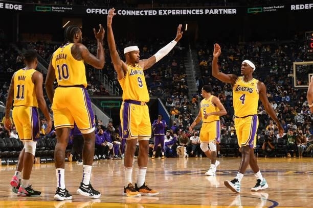 Kent Bazemore of the Los Angeles Lakers high fives DeAndre Jordan of the Los Angeles Lakers and Rajon Rondo of the Los Angeles Lakers during a...