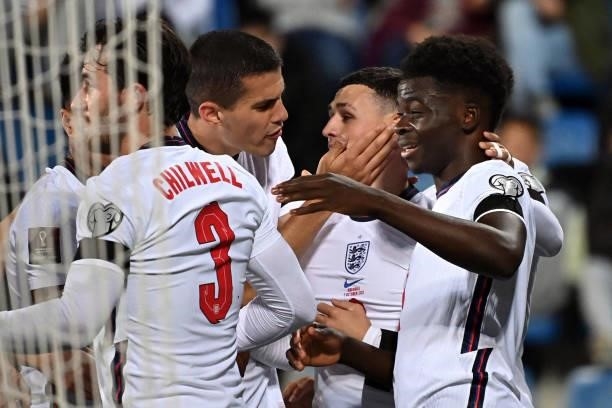 England's midfielder Bukayo Saka is congratulated by teammates after scoring a goal during the World Cup 2022 qualifier football match between...