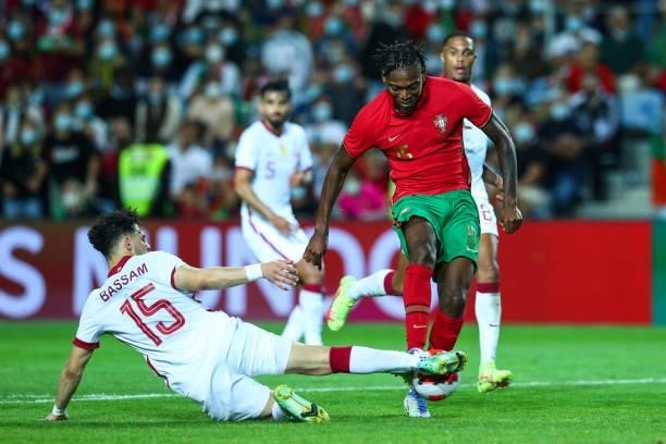 Bassam Hisham Alrawi of Qatar tackles Rafael Leao of AC Milan and Portugal during the international friendly match between Portugal and Qatar at...