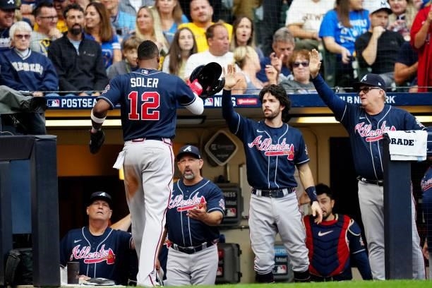 Jorge Soler of the Atlanta Braves is greeted in the dugout after scoring a run in the third inning during Game 2 of the NLDS between the Atlanta...