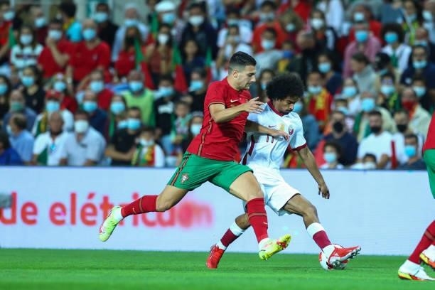 Diogo Dalot of AC Milan and Portugal vies with Akram Afif of Qatar for the ball possession during the international friendly match between Portugal...