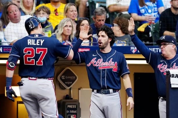 Austin Riley of the Atlanta Braves is greeted by teammate Dansby Swanson in the dugout after hitting a solo home in the sixth inning during Game 2 of...