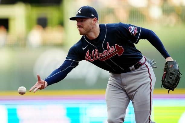 Freddie Freeman of the Atlanta Braves flips to first for the out during Game 2 of the NLDS between the Atlanta Braves and the Milwaukee Brewers at...