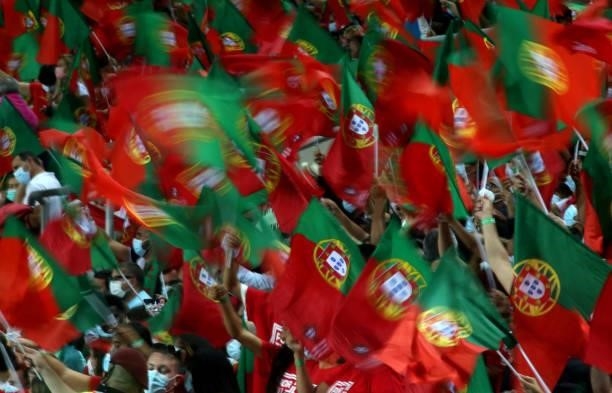 Fans of Portugal celebrate with a flag during the international friendly match between Portugal and Qatar at Estadio Algarve on October 9, 2021 in...