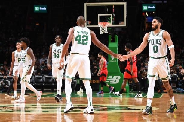 Al Horford of the Boston Celtics high fives Jayson Tatum of the Boston Celtics during a preseason game against the Toronto Raptors on October 9, 2021...