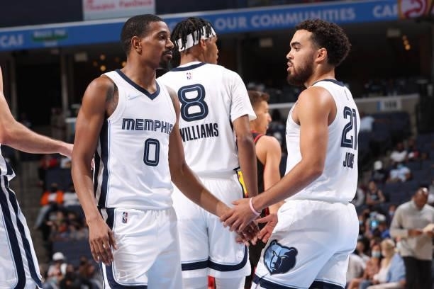 De'Anthony Melton of the Memphis Grizzlies high-fives teammate Tyus Jones during a preseason game against the Atlanta Hawks on October 9, 2021 at...