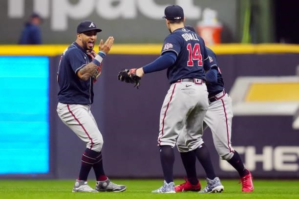 Eddie Rosario, Guillermo Heredia and Adam Duvall of the Atlanta Braves celebrate after the Braves defeated the Milwaukee Brewers 3-0 in Game 2 of the...