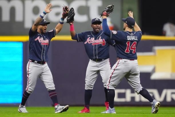 Eddie Rosario, Guillermo Heredia and Adam Duvall of the Atlanta Braves celebrate after the Braves defeated the Milwaukee Brewers 3-0 in Game 2 of the...