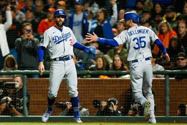 Cody Bellinger of the Los Angeles Dodgers hi fives Chris Taylor after crossing the plate during Game 2 of the NLDS between the Los Angeles Dodgers...