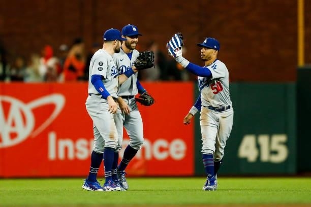 Mookie Betts of the Los Angeles Dodgers, Chris Taylor and AJ Pollock celebrate after beating the San Francisco Giants 9-2 in Game 2 of the NLDS at...