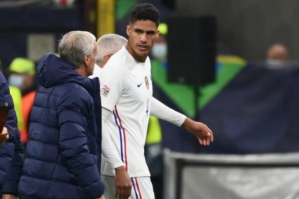 France's defender Raphael Varane speaks with France's coach Didier Deschamps as he leaves the pitch after getting injured during the Nations League...