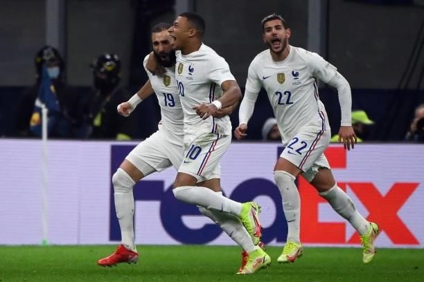 France's forward Karim Benzema celebrates with France's forward Kylian Mbappe and France's defender Theo Hernandez after scoring a goal during the...