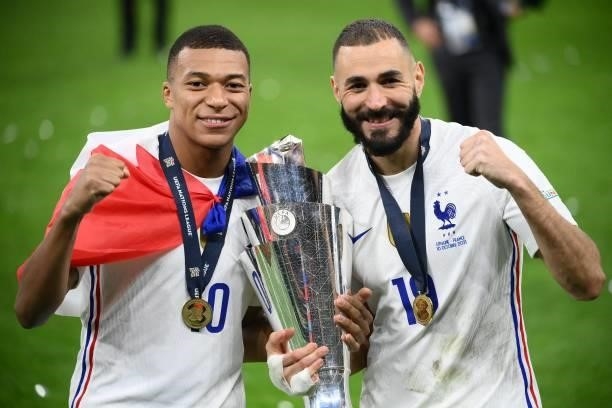 France's forward Kylian Mbappe and France's forward Karim Benzema celebrate with the trophy at the end of the Nations League final football match...