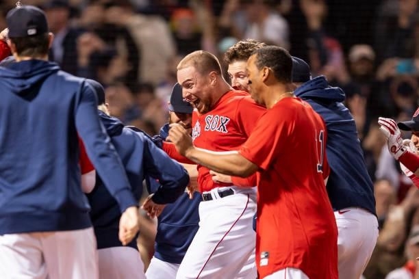 Christian Vazquez of the Boston Red Sox is mobbed by teammates after hitting a game winning walk-off two run home run during the thirteenth inning of...
