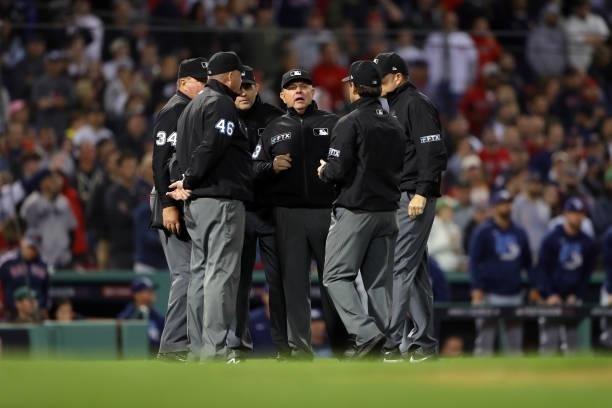 The umpire crew discusses a play on the field in the 13th inning during Game 3 of the ALDS between the Tampa Bay Rays and the Boston Red Sox at...
