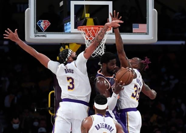 Anthony Davis and Dwight Howard of the Los Angeles Lakers double team Deandre Ayton of the Phoenix Suns under the net in the first half of a...