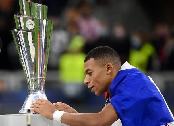 France's forward Kylian Mbappe touches the trophy at the end of the Nations League final football match between Spain and France at San Siro stadium...