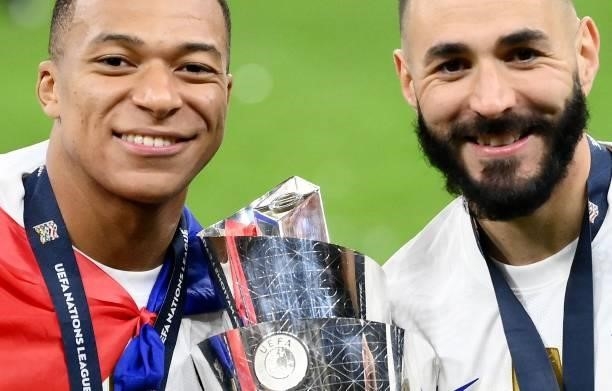 France's forward Kylian Mbappe and France's forward Karim Benzema pose with the trophy at the end of the Nations League final football match between...