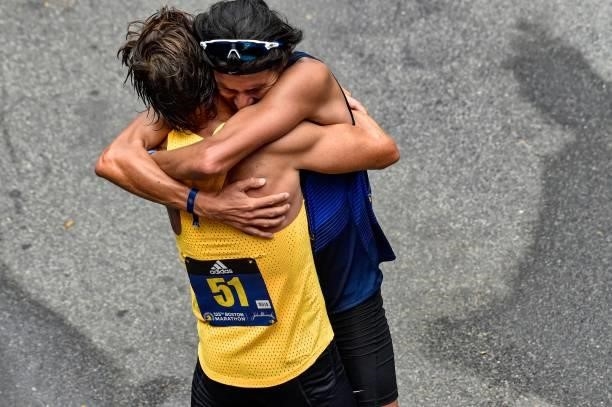 Blue Benadum and Luis Carlos Rivero embrace at the finish line after finishing the race during the 125th Boston Marathon in Boston, Massachusetts on...