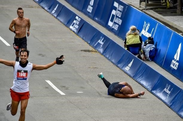 Runner collapses as he runs down Boylston Street during the 125th Boston Marathon in Boston, Massachusetts on October 11, 2021.