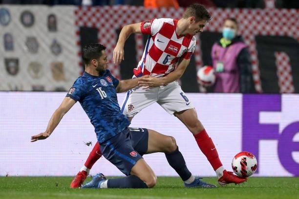 Josip Stanisic of Croatia in action against David Hancko of Slovakia during the 2022 FIFA World Cup Group H Qualifier match between Croatia and...