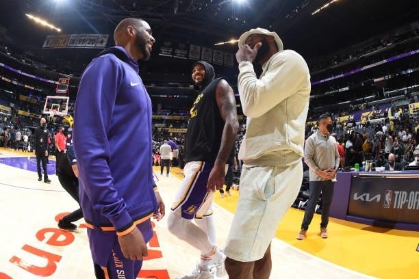 LeBron James, Carmelo Anthony of the Los Angeles Lakers and Chris Paul of the Phoenix Suns embrace after a preseason game on October 10, 2021 at...