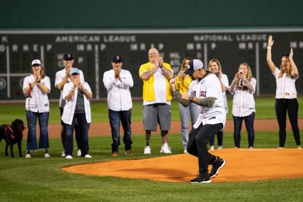 Former third baseman Will Middlebrooks of the Boston Red Sox reacts after throwing out a ceremonial first pitch alongside survivors of the Boston...