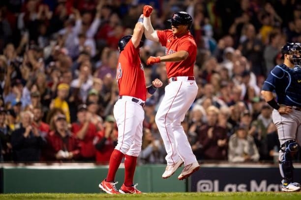 Rafael Devers of the Boston Red Sox reacts with Kyle Schwarber after hitting a three run home run during the third inning of game four of the 2021...
