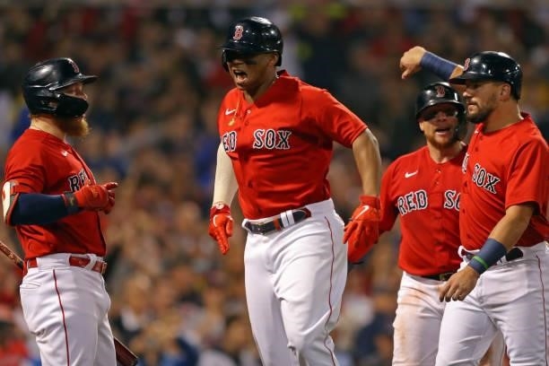 Rafael Devers of the Boston Red Sox celebrates with his teammates after hitting a home run in the bottom of the third inning during Game 4 of the...