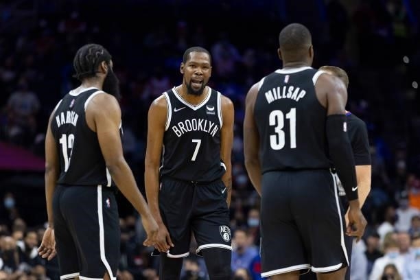Kevin Durant of the Brooklyn Nets reacts with of James Harden and Paul Millsap against the Philadelphia 76ers in the first half at the Wells Fargo...