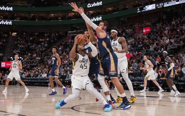 Jonas Valanciunas and Josh Hart of the New Orleans Pelicans trap Donovan Mitchell of the Utah Jazz during the first half of their game on October 11,...