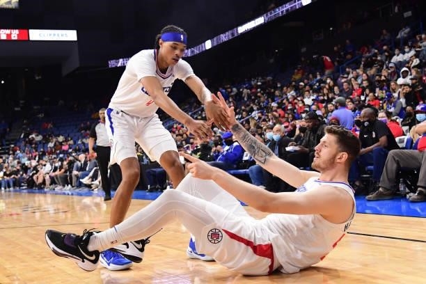 Brandon Boston Jr. #4 helps up Isaiah Hartenstein of the LA Clippers during a preseason game against the Minnesota Timberwolves on October 11, 2021...