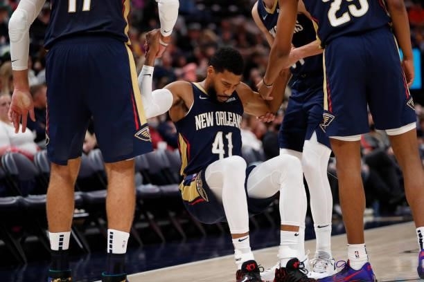 Garrett Temple of the New Orleans Pelicans is helped up by his teammates during a preseason game against the Utah Jazz on October 11, 2021 at...