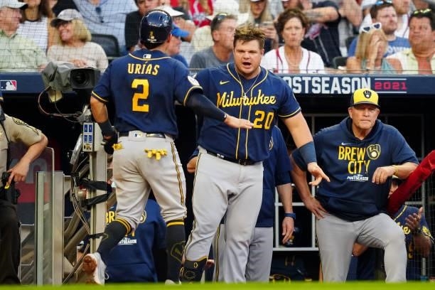 Luis Urías of the Milwaukee Brewers celebrates with teammate Daniel Vogelbach after scoring a run in the top of the fourth inning during Game 4 of...